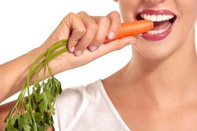 La fille mange des carottes crues
